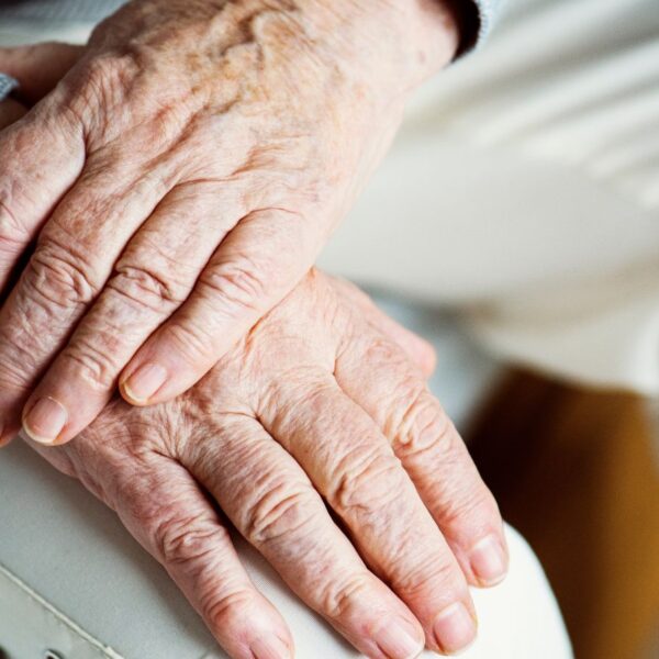 A close-up of an elderly person’s hands resting together, illustrating the physical impact of Parkinson’s disease for patients seeking medical cannabis in Alabama.