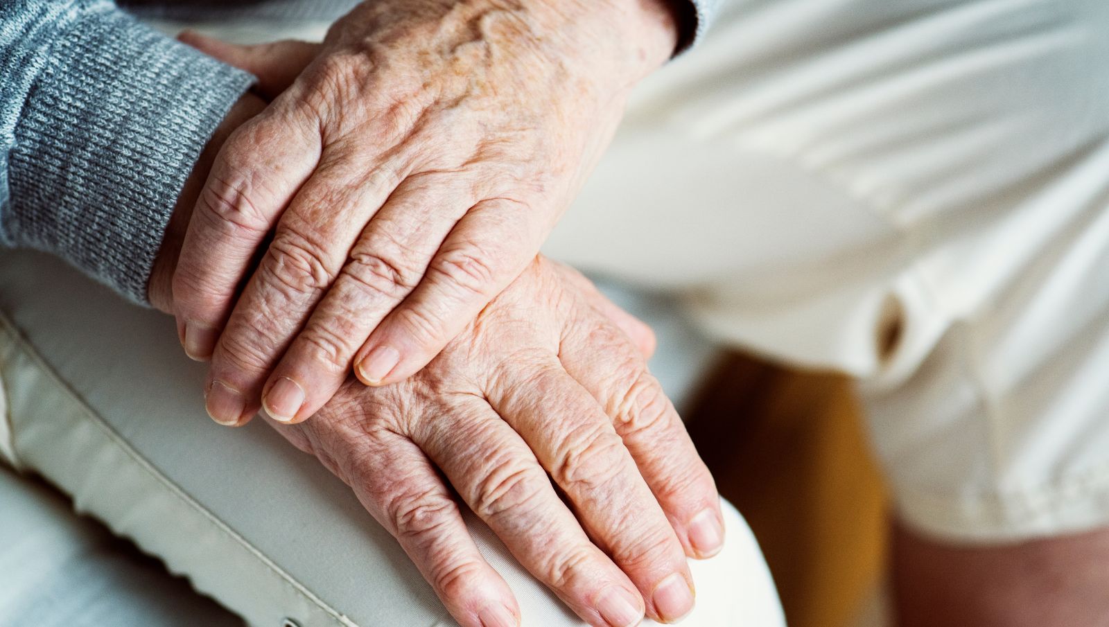 A close-up of an elderly person’s hands resting together, illustrating the physical impact of Parkinson’s disease for patients seeking medical cannabis in Alabama.