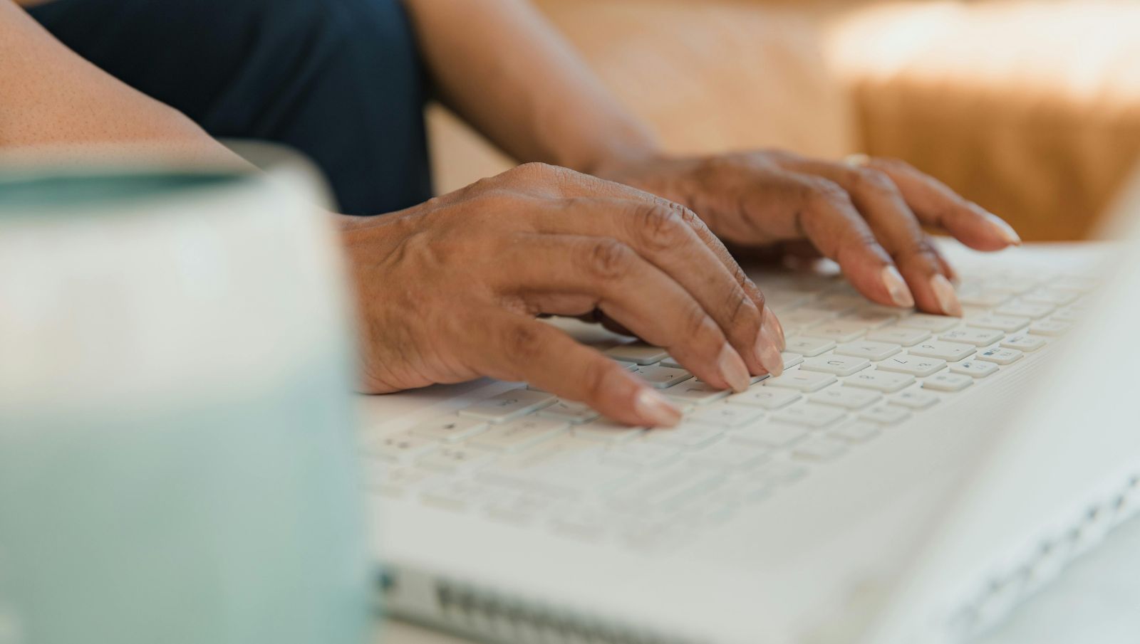 Close-up of a medical cannabis patient’s hands entering personal information into the official Alabama Medical Cannabis Commission (AMCC) registration portal.