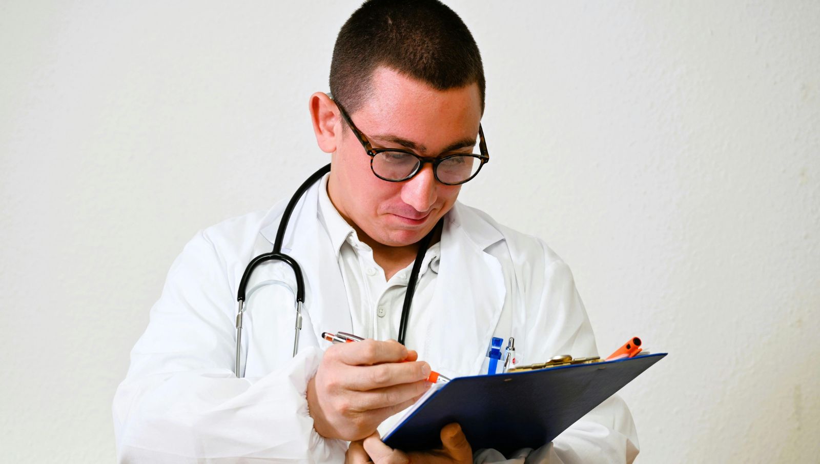 A friendly doctor smiling at the camera in a clinical setting representing accessible medical cannabis care in Cullman, Alabama.
