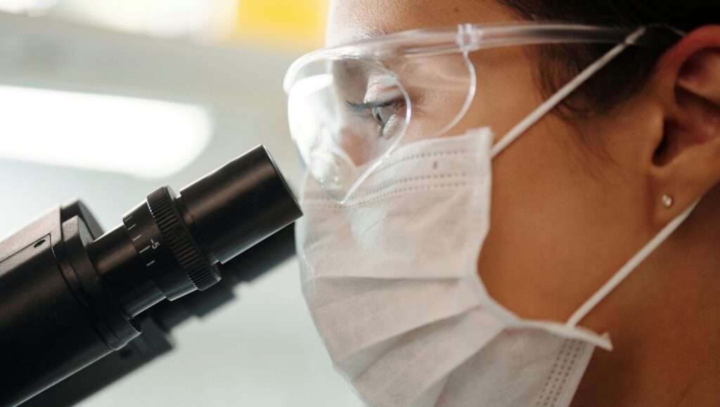A laboratory scientist looking into a microscope to analyze medical cannabis terpene profiles for Alabama patients.