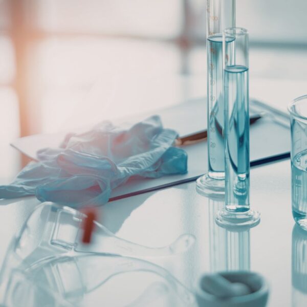 A scientist in a laboratory looking into a microscope to analyze cannabis plant compounds like terpenes and flavonoids.
