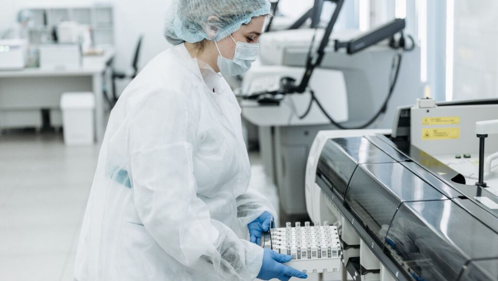 A cannabis researcher in white lab coats studying cannabinoids and testing pharmaceutical grade medical cannabis formulations in a laboratory.