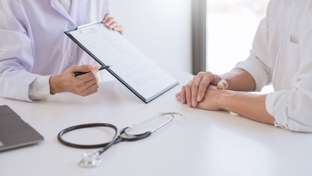 Close-up of a physician's clipboard as caregiver requirements are reviewed with the parent of a minor