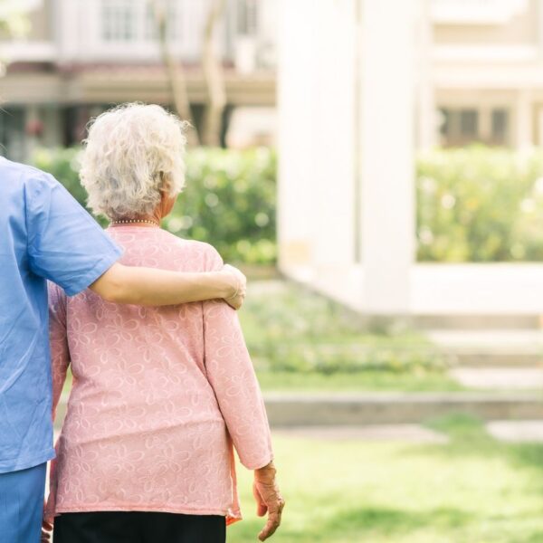 Registered medical cannabis caregiver in Alabama walking outdoors with a senior patient