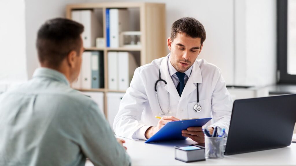 A registered Alabama certifying physician sitting face-to-face with a patient in a clinical office setting during an in-person evaluation.
