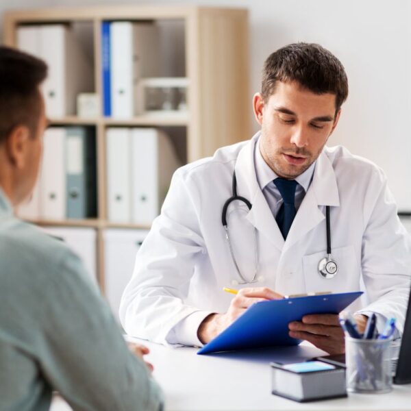 A registered Alabama certifying physician sitting face-to-face with a patient in a clinical office setting during an in-person evaluation.