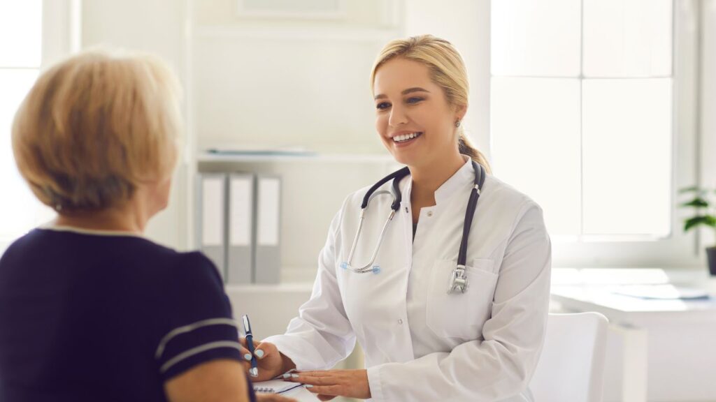 Patient viewed from behind speaking in-person with a certifying physician for an Alabama medical cannabis card renewal.